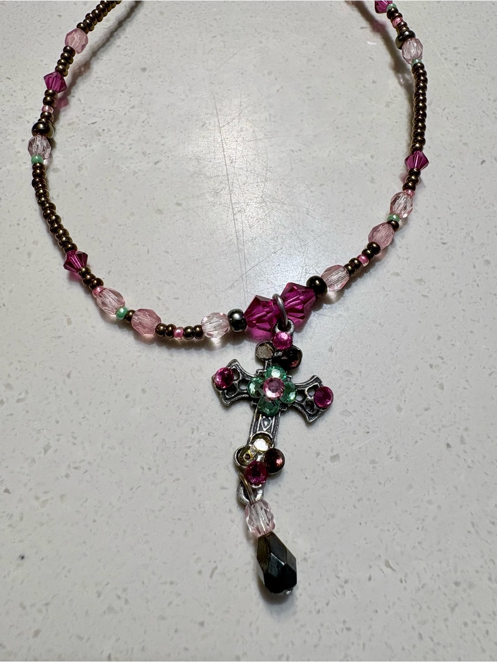 Silvertone cross with pink and green crystals